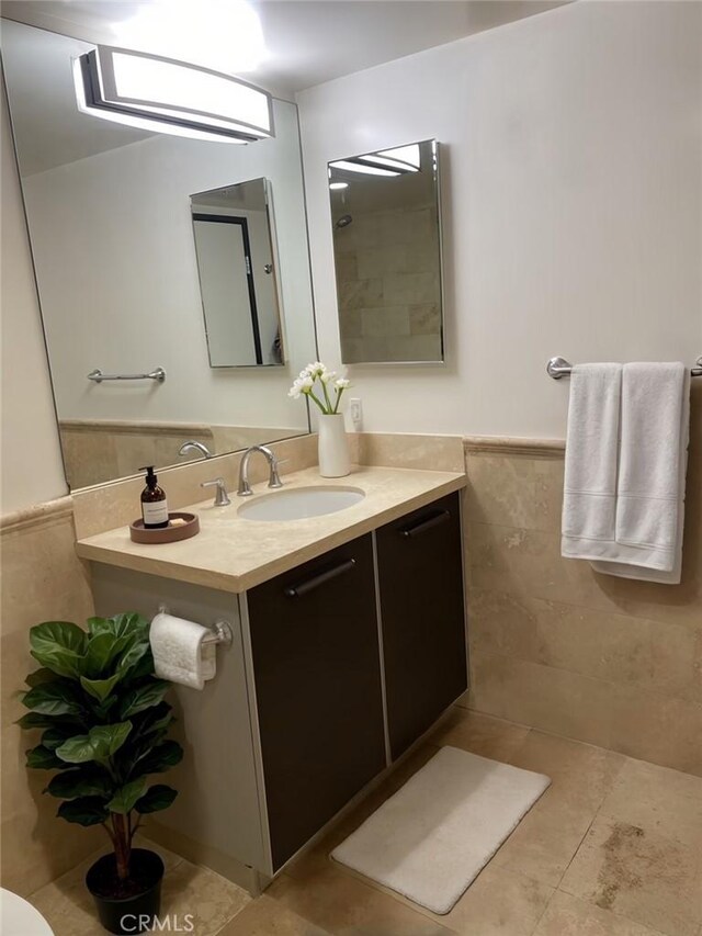 bathroom featuring vanity, tile patterned flooring, and tile walls