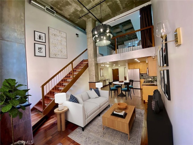 living room with sink, hardwood / wood-style floors, and a high ceiling