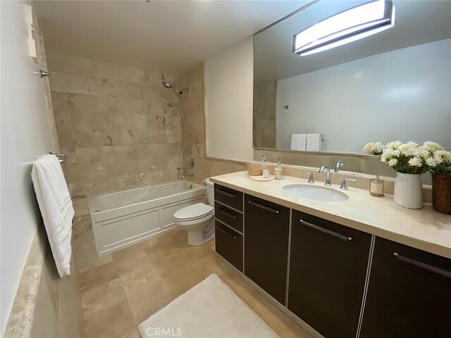 full bathroom featuring vanity, tiled shower / bath, and toilet