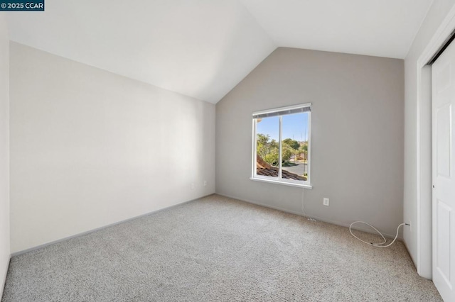 unfurnished bedroom featuring lofted ceiling, carpet floors, and a closet