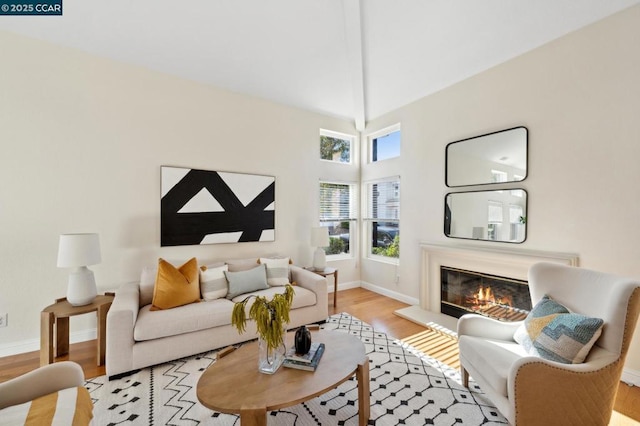 living room featuring lofted ceiling, a healthy amount of sunlight, and light hardwood / wood-style floors