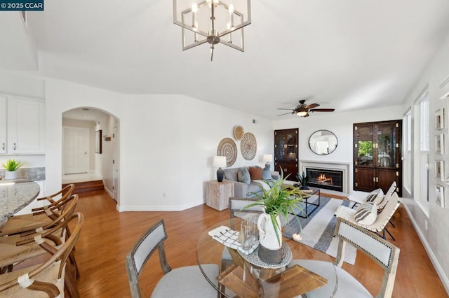 dining area featuring ceiling fan with notable chandelier and light wood-type flooring