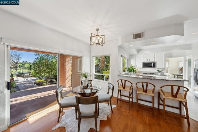 dining space featuring a chandelier and light wood-type flooring