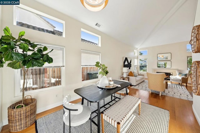 dining space featuring plenty of natural light, hardwood / wood-style floors, and high vaulted ceiling