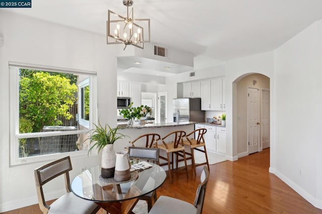 dining room with a chandelier and light wood-type flooring