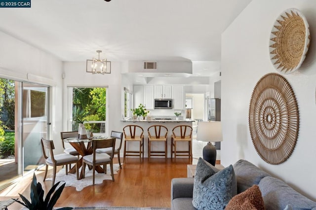 dining room with hardwood / wood-style flooring and a notable chandelier