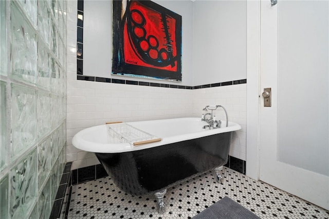 bathroom featuring tile walls, tile patterned floors, and a tub to relax in