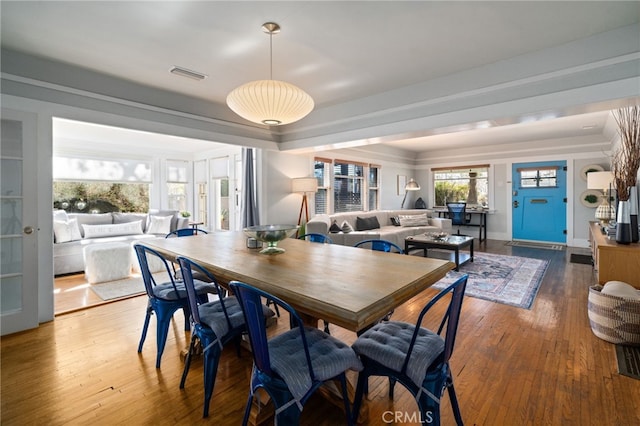 dining room featuring a tray ceiling and hardwood / wood-style flooring