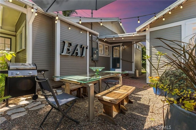 patio terrace at dusk featuring area for grilling