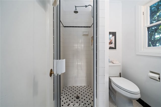 bathroom with toilet and a shower with shower door