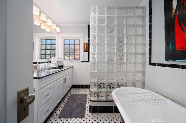 bathroom with tile patterned flooring, vanity, tile walls, and crown molding