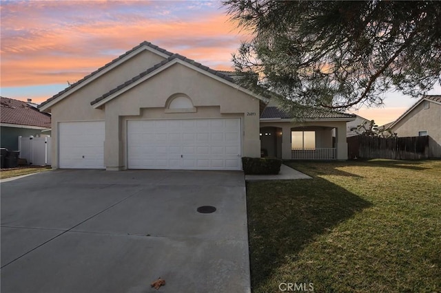 ranch-style home with a garage and a lawn