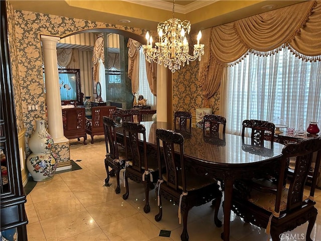 dining room featuring decorative columns, an inviting chandelier, a tray ceiling, ornamental molding, and light tile patterned flooring