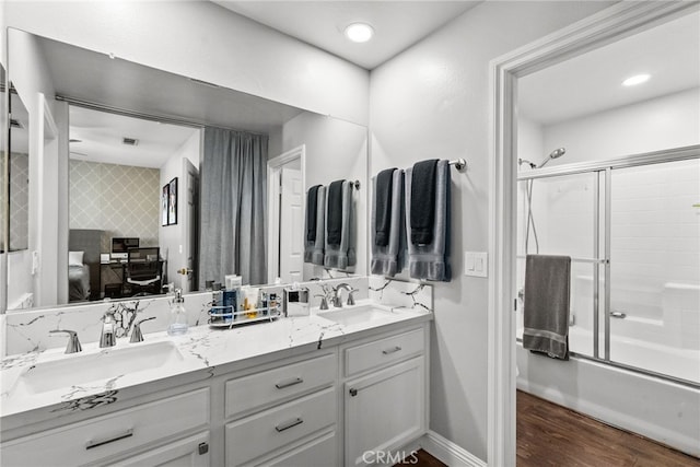 bathroom featuring vanity, hardwood / wood-style flooring, and enclosed tub / shower combo