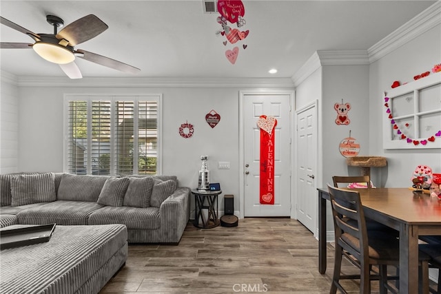 living room with hardwood / wood-style floors, ornamental molding, and ceiling fan