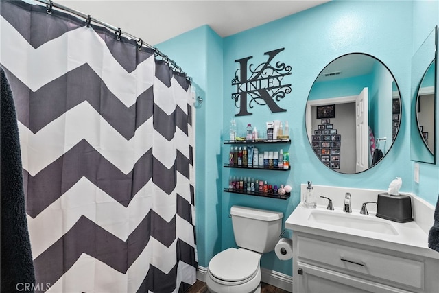 bathroom with vanity, toilet, and curtained shower