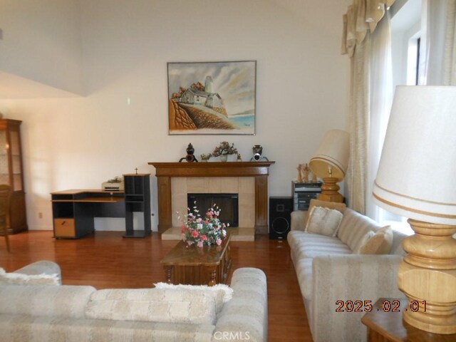 living room with hardwood / wood-style flooring and a tile fireplace