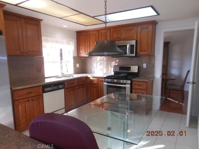 kitchen featuring light tile patterned flooring, sink, tasteful backsplash, ventilation hood, and stainless steel appliances