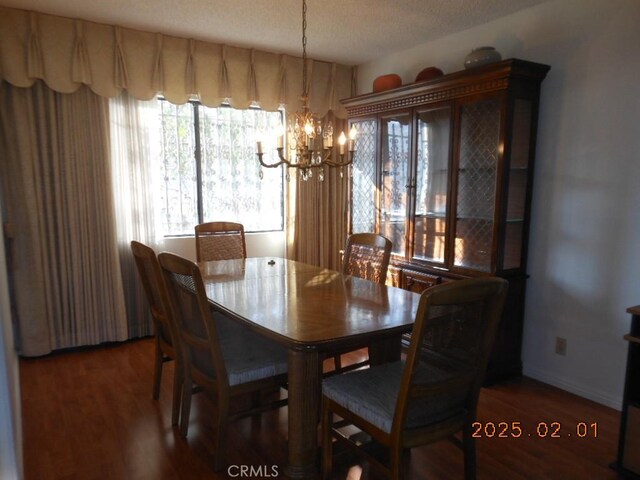 dining room featuring dark hardwood / wood-style flooring, a textured ceiling, and a chandelier