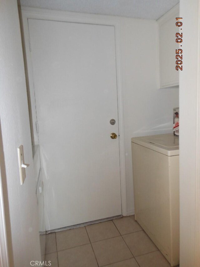 clothes washing area featuring light tile patterned floors and washer / dryer