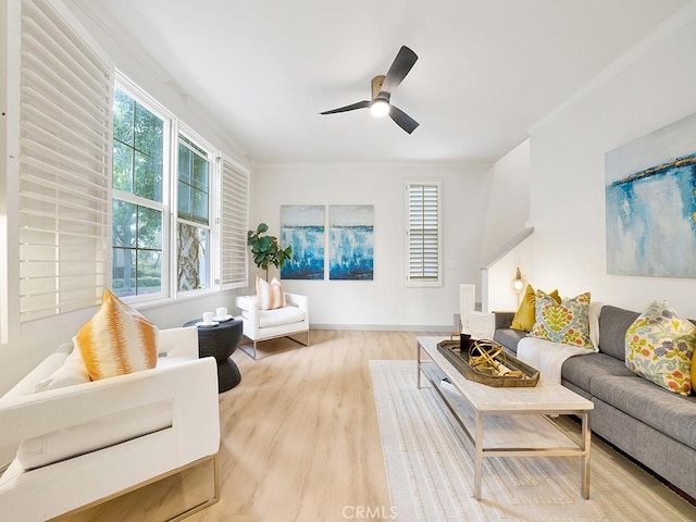 living room with ornamental molding, a wealth of natural light, ceiling fan, and light hardwood / wood-style flooring