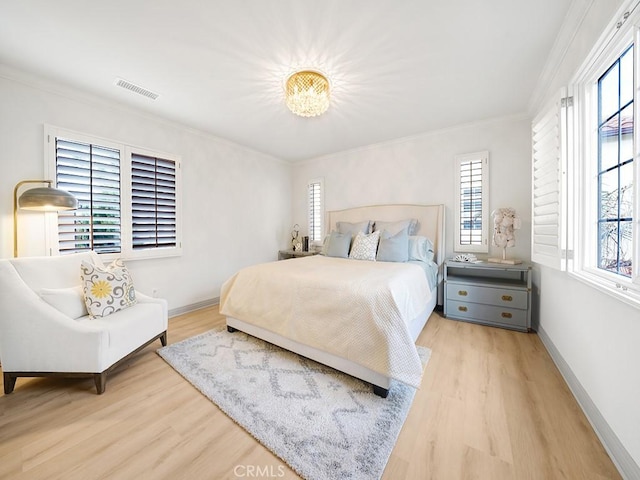 bedroom featuring ornamental molding and light hardwood / wood-style floors