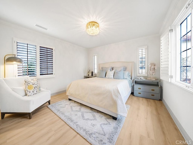 bedroom featuring crown molding, multiple windows, wood finished floors, and visible vents
