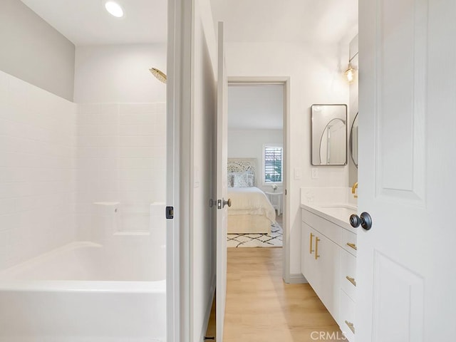 bathroom featuring vanity, wood-type flooring, and tub / shower combination