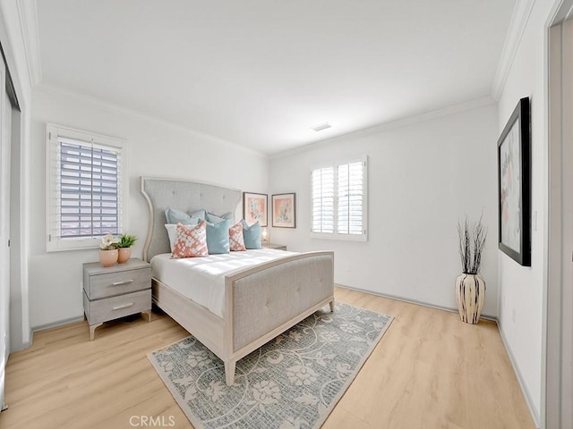 bedroom featuring crown molding, multiple windows, and light wood-style flooring