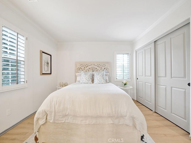 bedroom with a closet, crown molding, and light wood-type flooring
