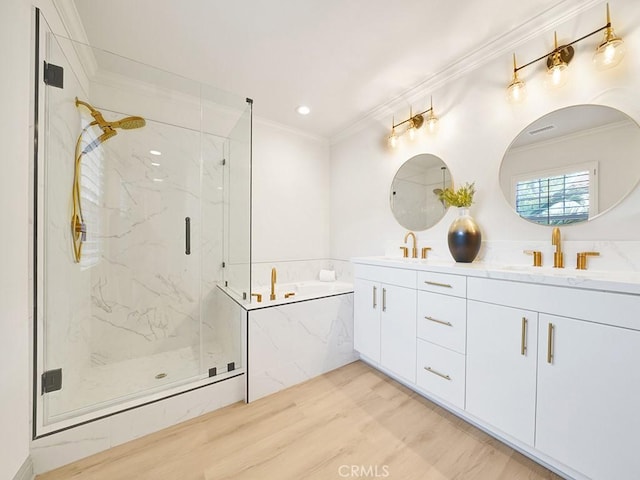 full bath with double vanity, wood finished floors, a marble finish shower, a sink, and crown molding