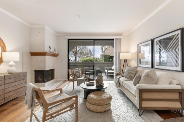 living room featuring a multi sided fireplace, ornamental molding, and light hardwood / wood-style flooring