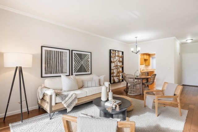 living room featuring an inviting chandelier, ornamental molding, and wood-type flooring