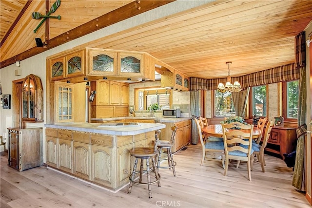 kitchen with lofted ceiling with beams, wood ceiling, and light hardwood / wood-style flooring