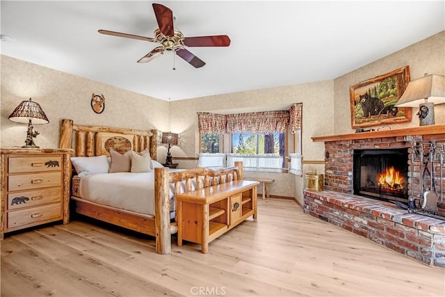 bedroom featuring a brick fireplace and light wood-type flooring