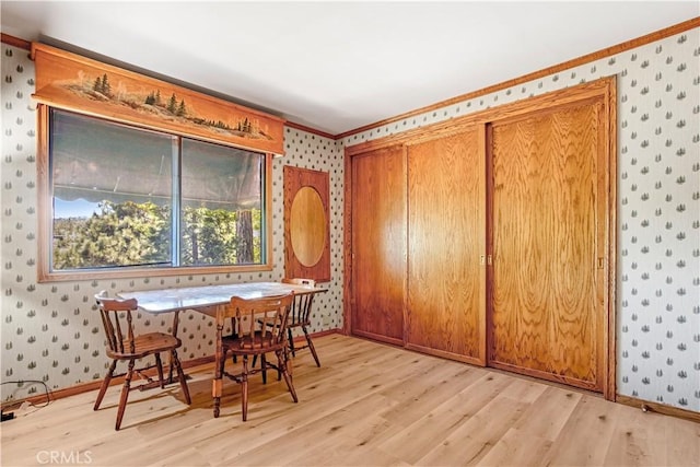 dining area with crown molding and light hardwood / wood-style floors