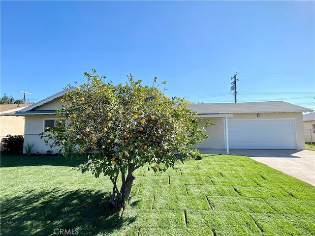 view of front of home with a garage, concrete driveway, a front lawn, and stucco siding