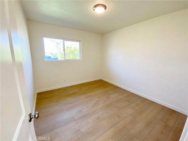 empty room featuring light wood-style floors and baseboards