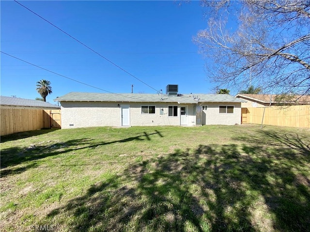 rear view of property featuring a yard, central air condition unit, a fenced backyard, and stucco siding