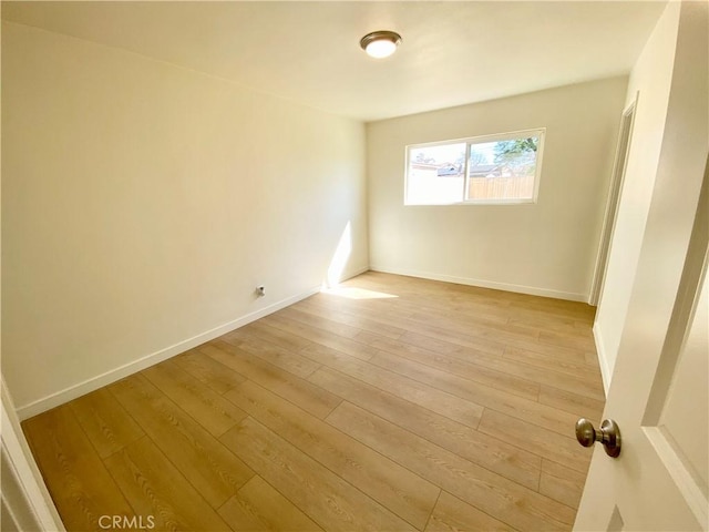 empty room featuring light wood-style flooring and baseboards