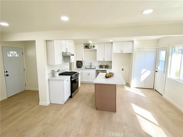 kitchen featuring a kitchen island, white cabinetry, stainless steel appliances, and light countertops