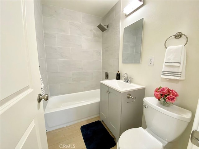 bathroom featuring bathtub / shower combination, vanity, and toilet