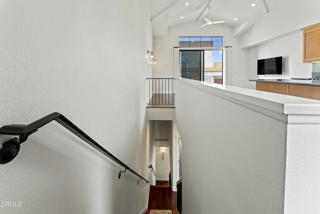 stairway with beamed ceiling and high vaulted ceiling