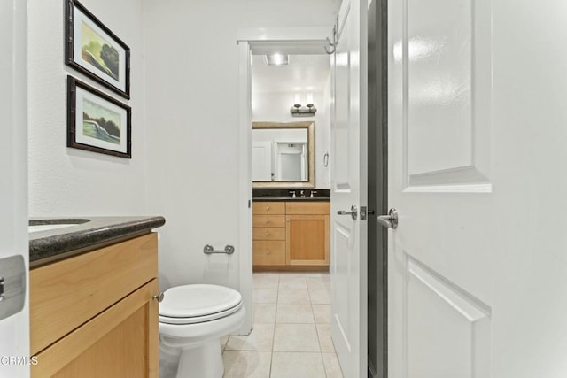 bathroom with vanity, toilet, and tile patterned flooring