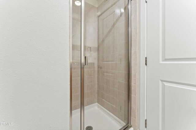 bathroom featuring a shower with door