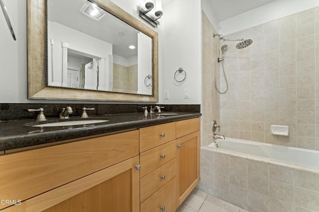 bathroom featuring tile patterned flooring, vanity, and tiled shower / bath