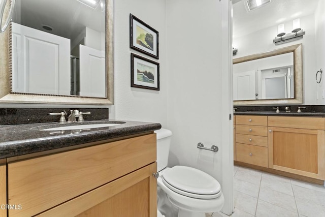 bathroom featuring vanity, toilet, and tile patterned flooring