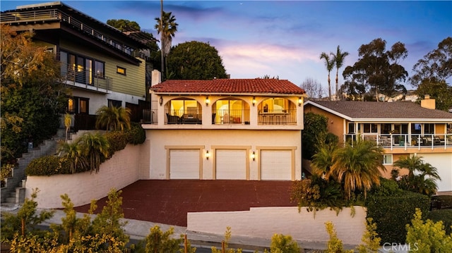 mediterranean / spanish-style home featuring a balcony and a garage