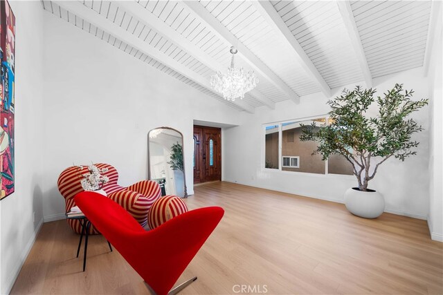 living area featuring lofted ceiling with beams, wood-type flooring, a notable chandelier, and wood ceiling