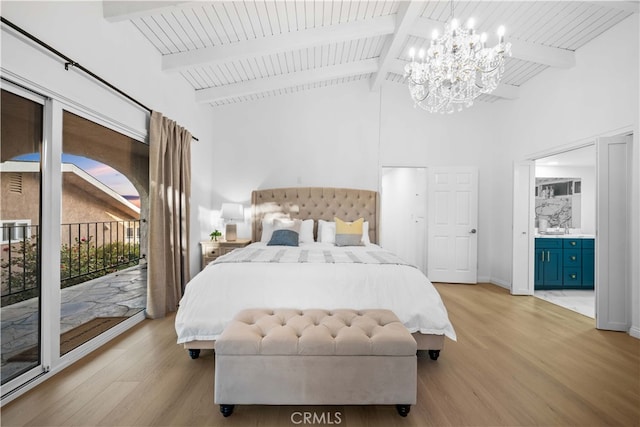 bedroom featuring ensuite bathroom, light wood-type flooring, a chandelier, access to exterior, and beam ceiling